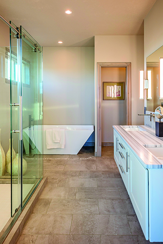 A glass shower, unique striped quartz sink and stand-alone tub highlight the master bath. 