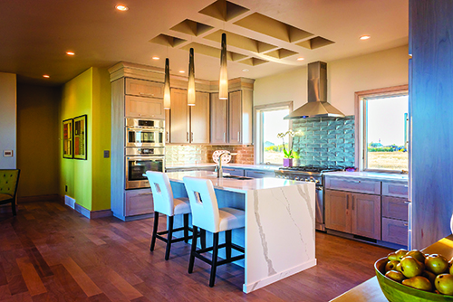 A waterfall styled kitchen island and coffered ceiling provides a gorgeous centerpiece for the kitchen.